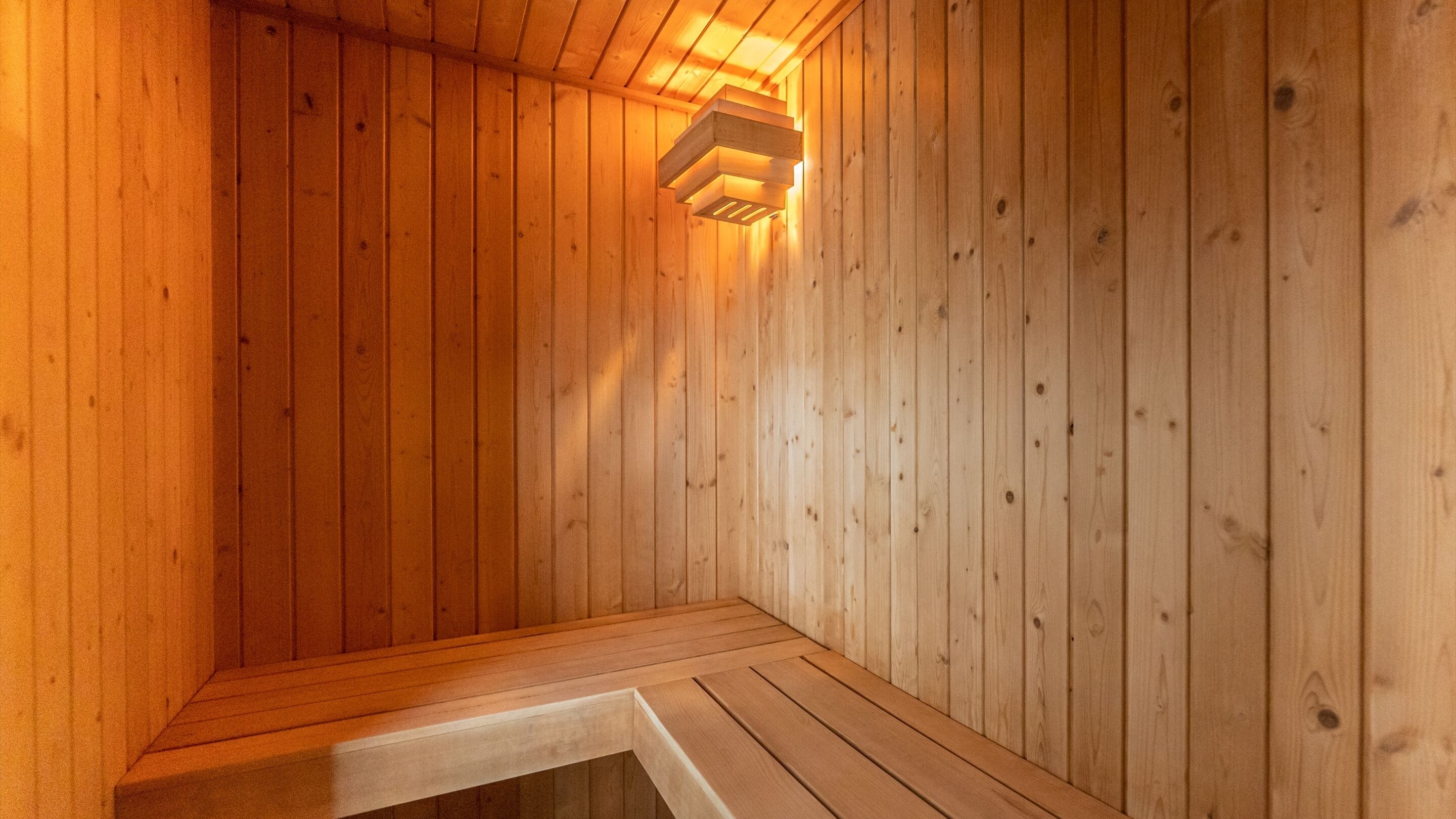 A sauna with wooden walls and a bench.