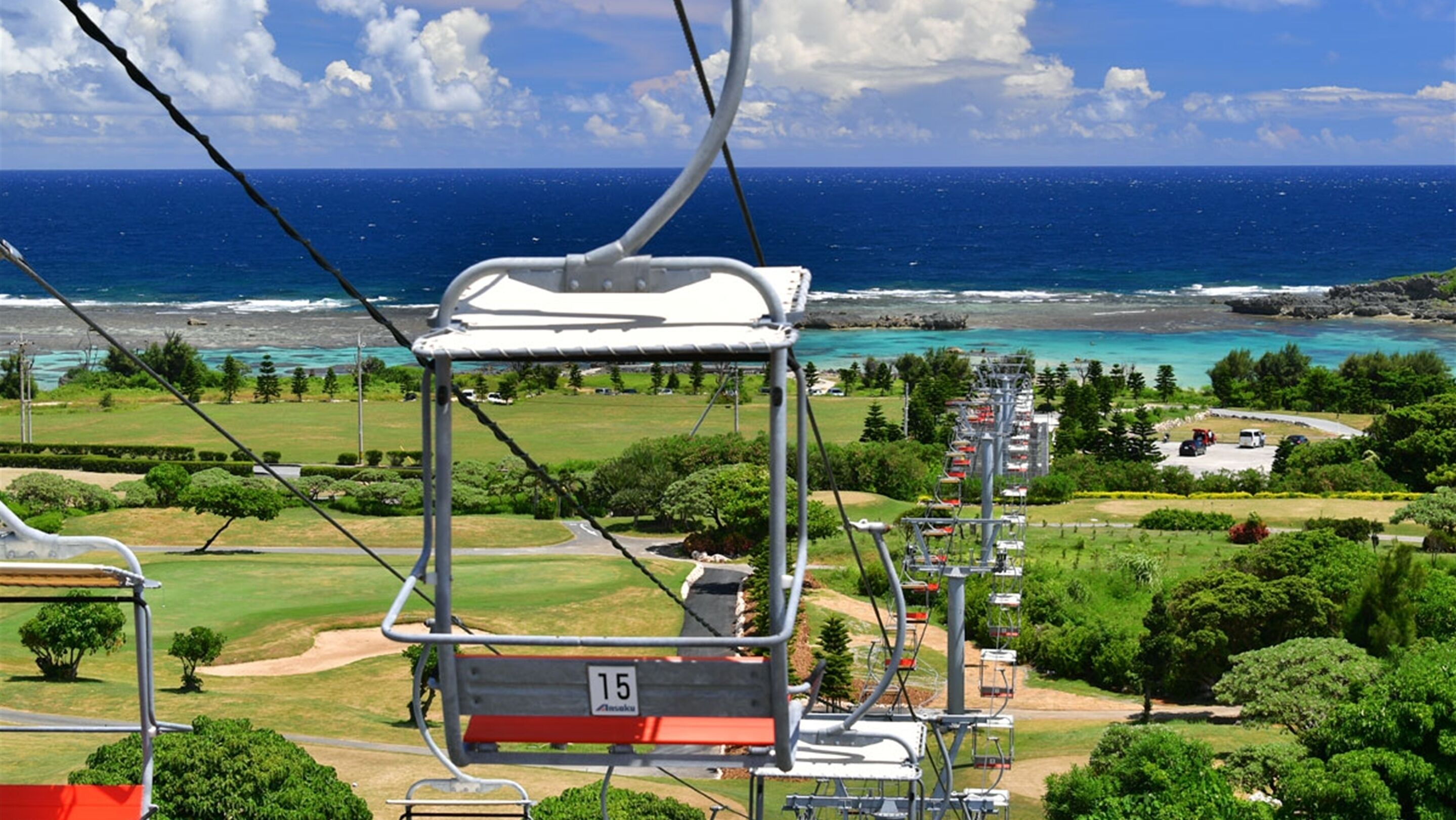 Une télécabine offrant une vue sur un paysage côtier, notamment une plage et l’océan.