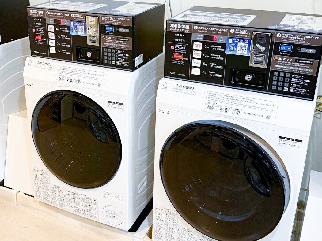 Two front-loading washing machines with control panels, placed side by side.