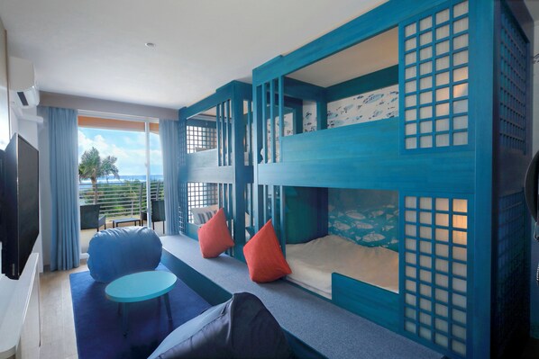 A room with a bunk bed, a sofa, and a small table.