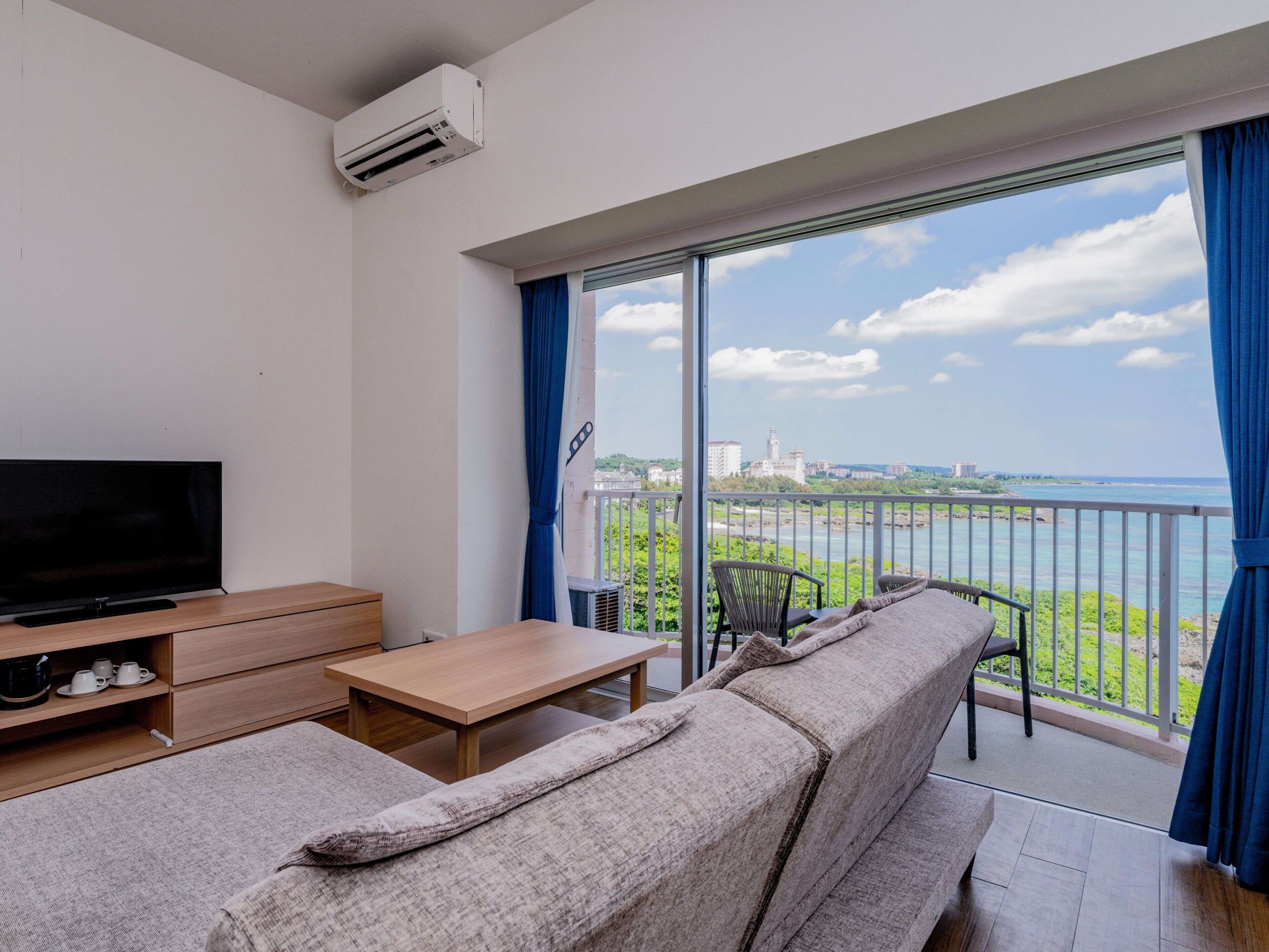 A balcony with a sofa, a TV, and a table.