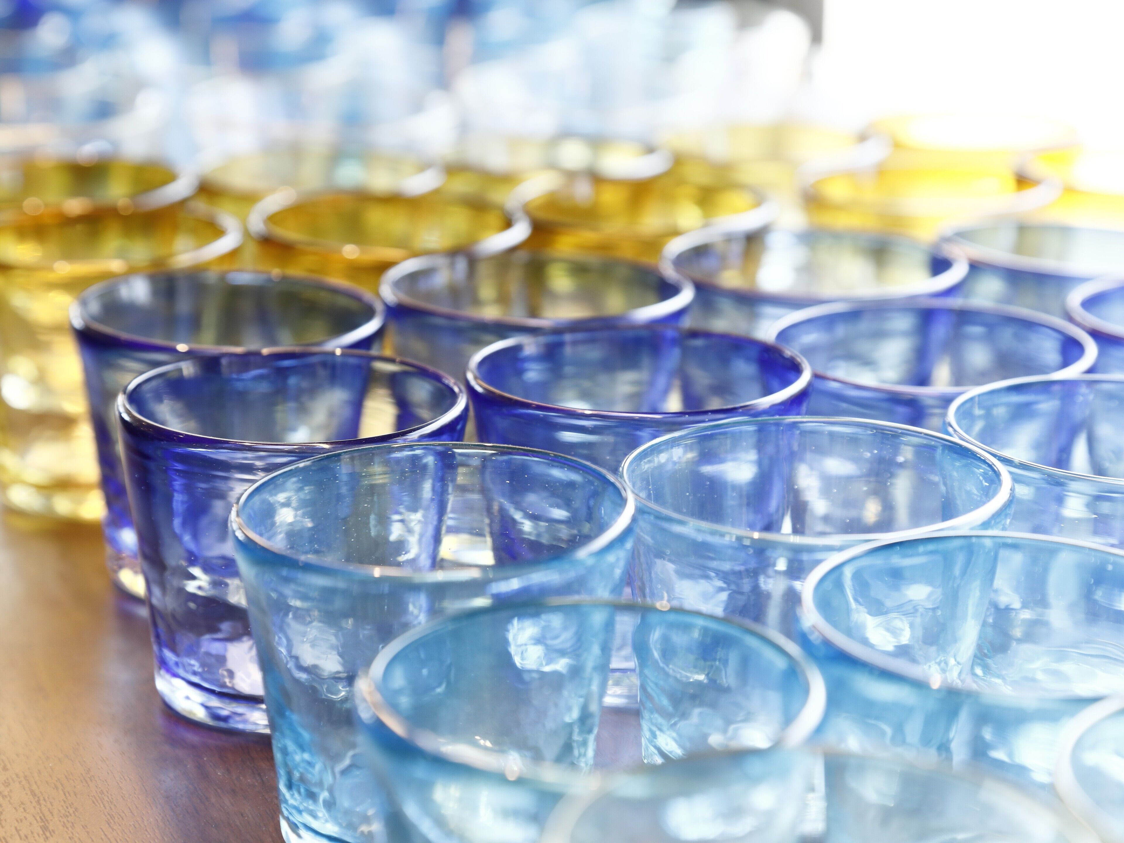 Varios vasos de vidrio transparente dispuestos sobre una superficie de madera.