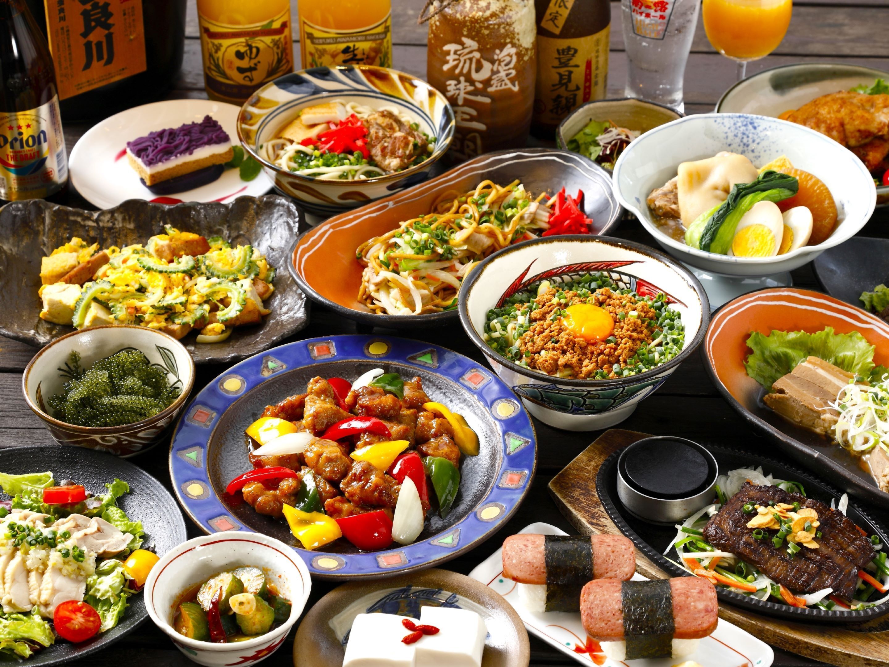 A variety of dishes on a table, including noodles, meat, and vegetables.