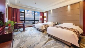 A hotel room with two beds, a desk, a chair, a TV, and a large window with a view. - Wanfu International Hotel (Xianyang)