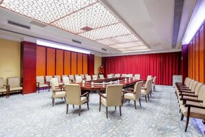 A conference room with a long table, chairs, and a red curtain backdrop. - Wanfu International Hotel (Xianyang)