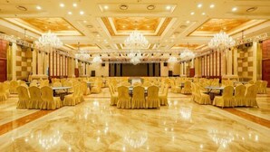 A banquet hall with a polished marble floor, rows of tables with chairs, and chandeliers. - Wanfu International Hotel (Xianyang)