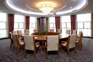 A conference room with a round table, chairs, and a chandelier. - Wanfu International Hotel (Xianyang)