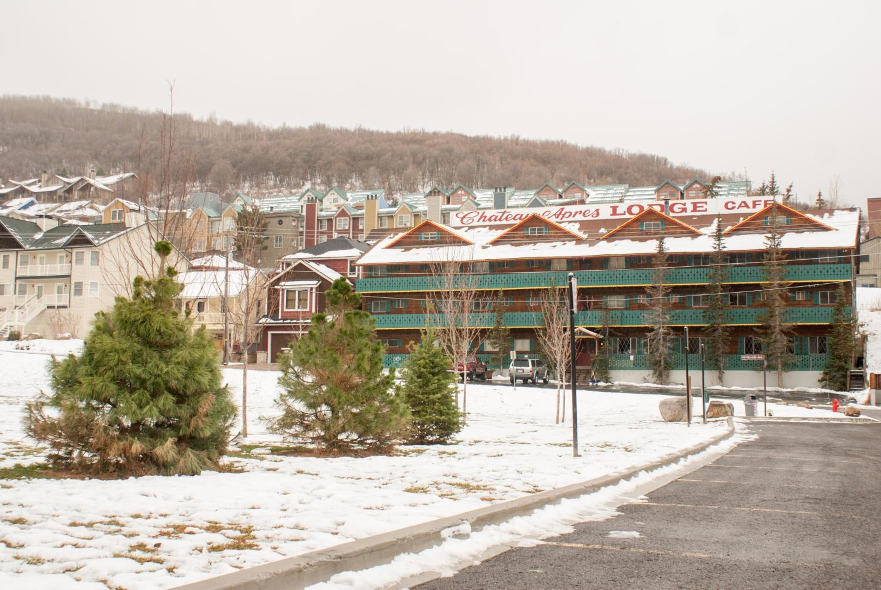 A lodge with a prominent sign, surrounded by snow-covered ground and trees.