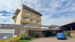 La entrada al Hotel Cristal Palace con un automóvil estacionado en la entrada.