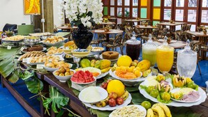 Una mesa de buffet con frutas, verduras y bebidas varias.