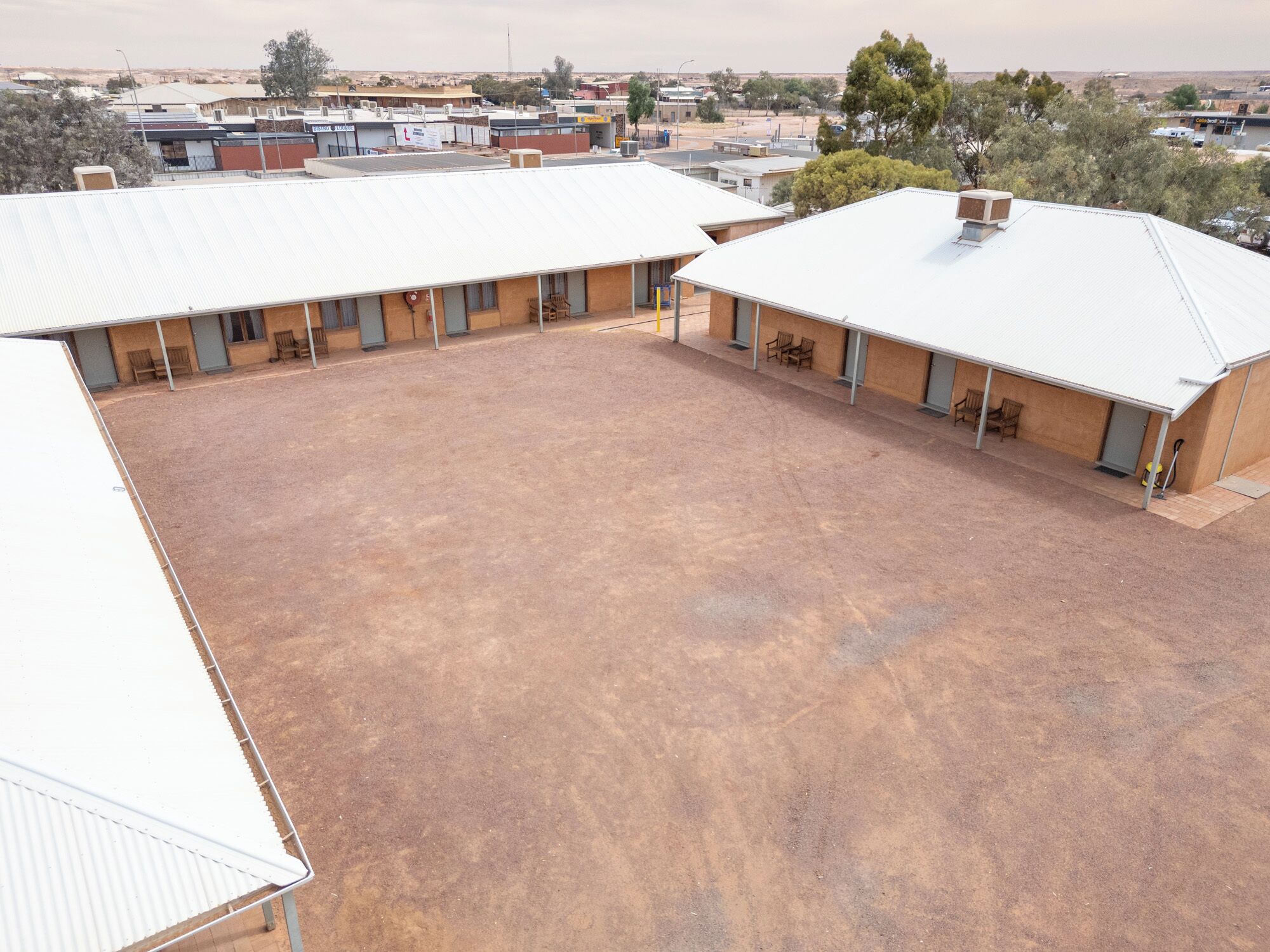 A large, open building with multiple rooms, a covered courtyard, and a flat roof.