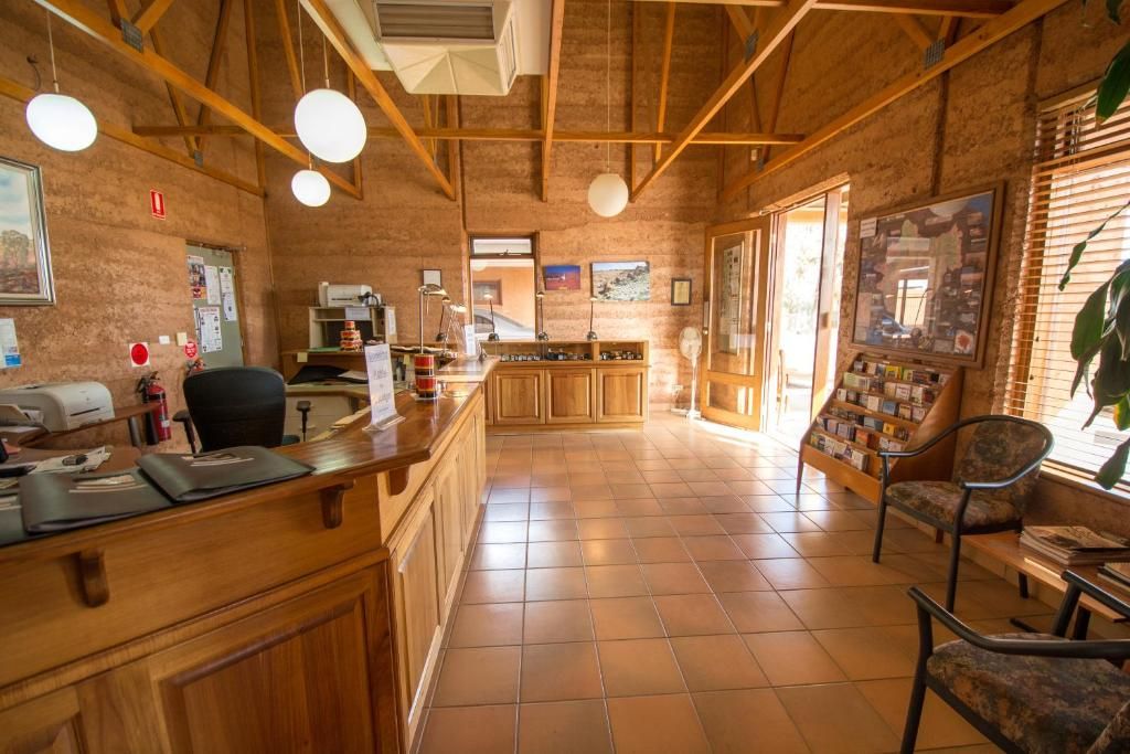 Una zona de recepción con mostrador de madera, asientos y vistas al exterior.
