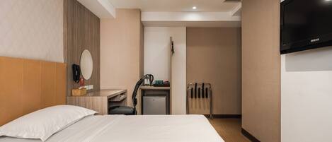 Een hotelkamer met twee bedden, een bureau met stoel, een televisie en een kleine kitchenette.