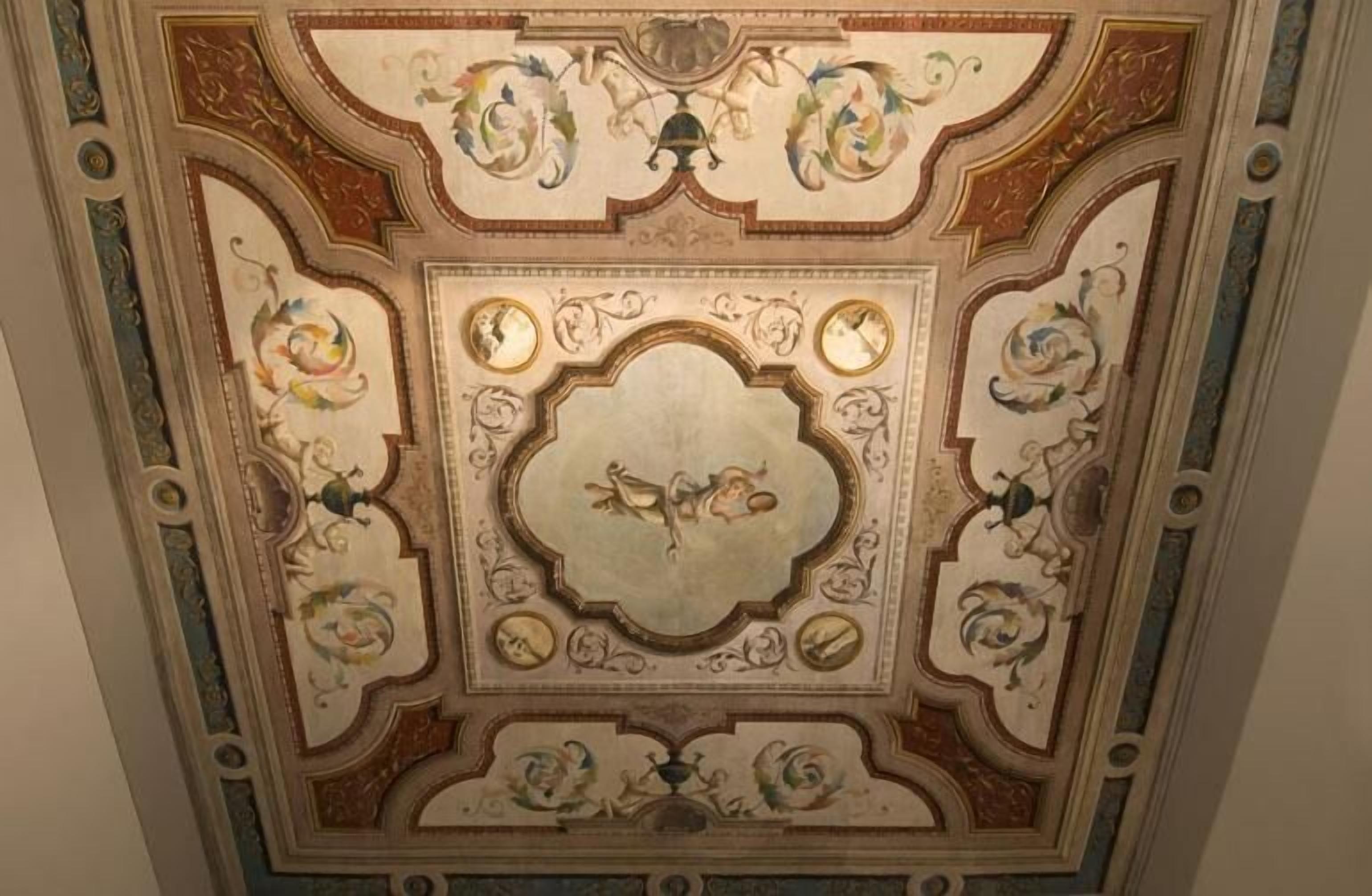 A detailed ceiling with ornate designs and a central medallion.