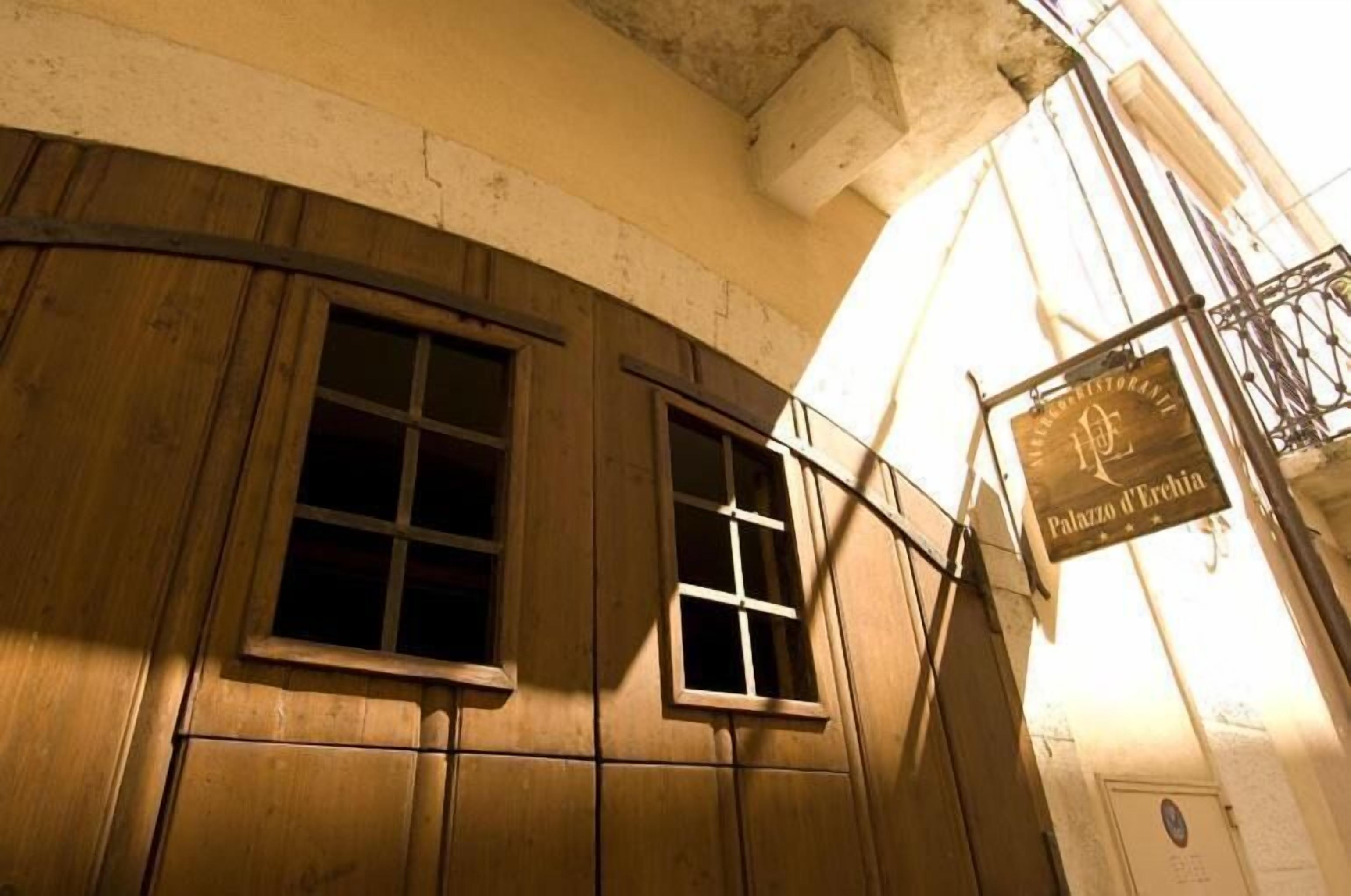 Een gevel met houten lambrisering en een bord waarop 