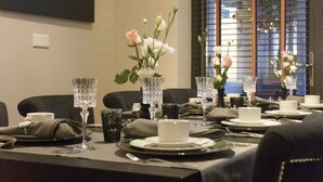 A dining area with a table set for four, featuring clear glassware and floral centerpieces. - Bliss Boutique Hotel (Breda)