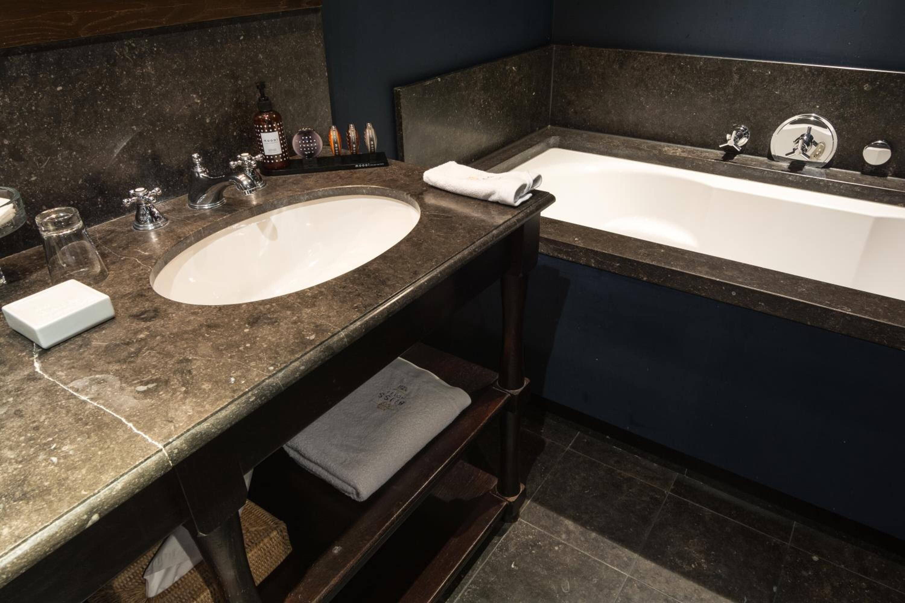 Un baño con lavamanos doble, bañera y perchero para toallas.