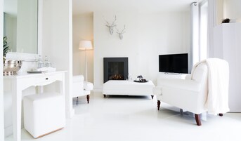 Deluxe Suite with balcony | Living room | TV, fireplace, DVD player