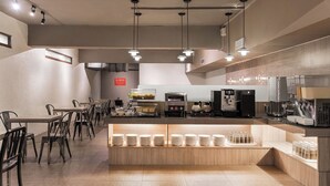 A modern cafe with a long counter, multiple seating areas, and a visible coffee machine. - The Riverside Hotel Hengchun (Hengchun)