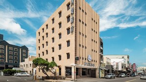 A hotel with a modern design, featuring a prominent entrance and a clear sky in the background. - The Riverside Hotel Hengchun (Hengchun)