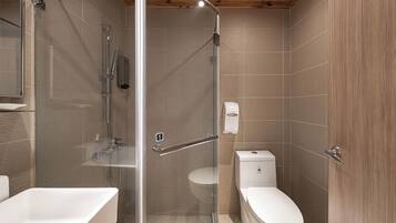 Un baño moderno con ducha de vidrio, inodoro blanco y bañera.
