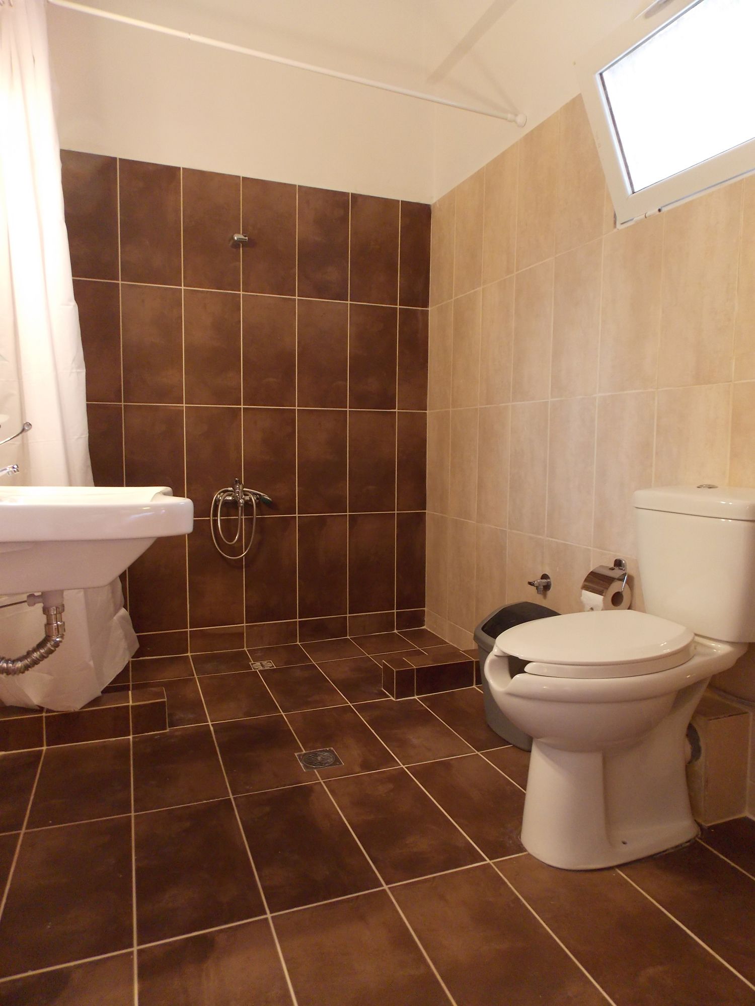 Un baño con ducha, inodoro y lavamanos.