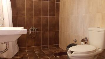 Un baño con ducha, inodoro y lavamanos.