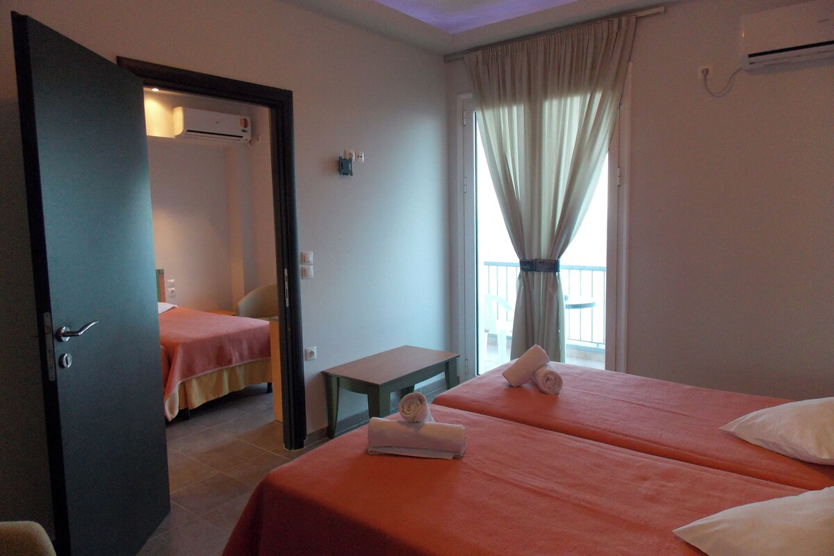 Une chambre d’hôtel avec deux lits, une petite table et une vue sur l’extérieur.