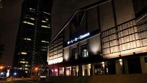 Un edifici modern amb un cartell de cinema, grans finestres i una entrada destacada.