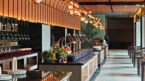 A modern bar area with a long counter, multiple light fixtures, and a variety of bar tools and bottles. - Sono Calm Gyeongju (Gyeongju)