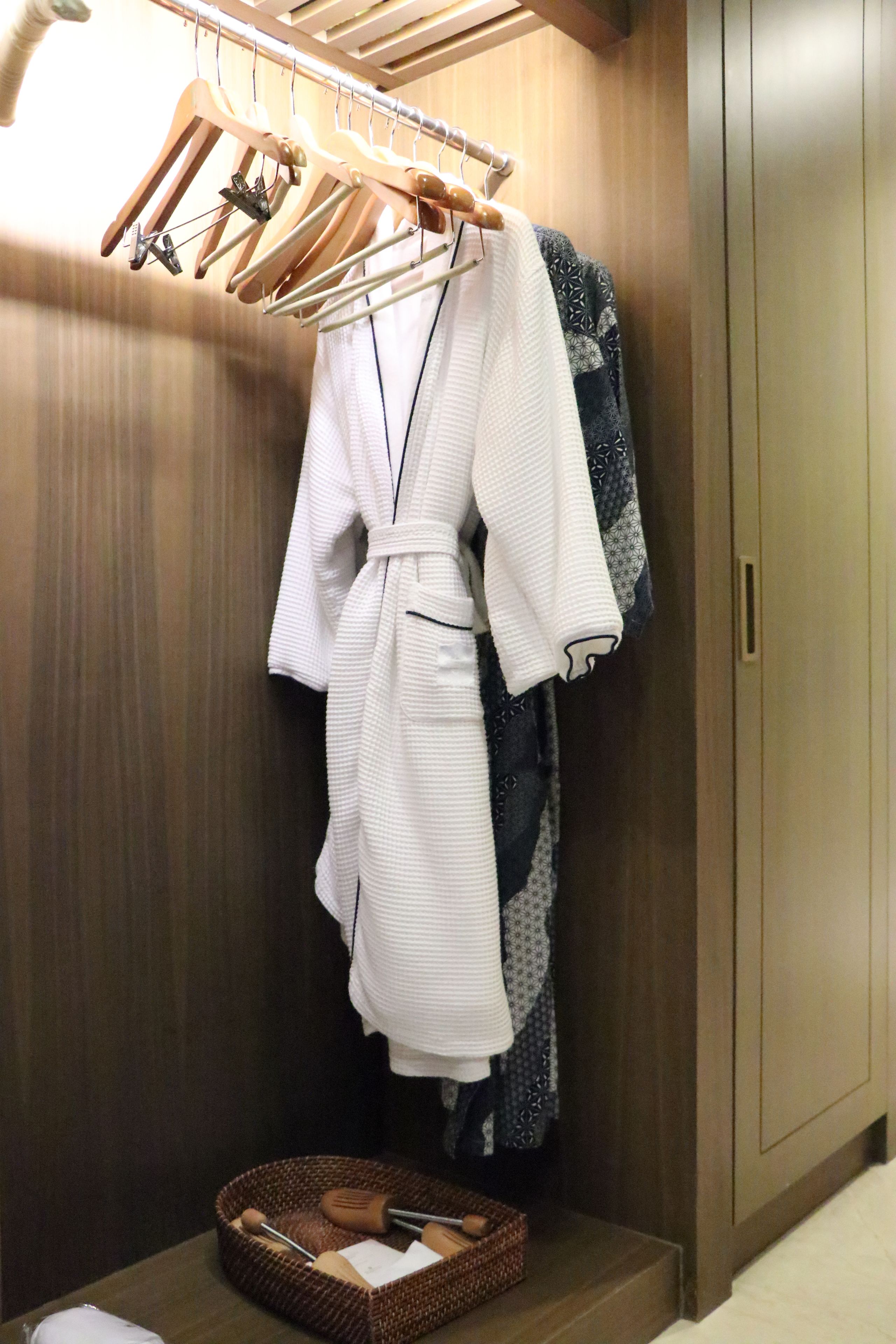 A wooden wardrobe with a hanging rack above it.
