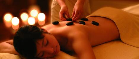 Une personne recevant un massage aux pierres chaudes sur le dos.