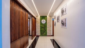 A hallway with a wooden door, a sign for Marble Pandora Restaurant, and framed pictures on the wall. - Hennessis Hotel (Nairobi)