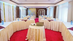 A conference room with round tables, laptops, and water bottles. - Hennessis Hotel (Nairobi)