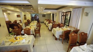 Un comedor con varias mesas y sillas dispuestas en filas.