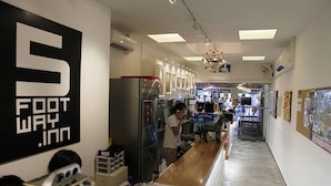 Un HOTEL FIVE FOOT WAY con una barra larga, refrigeradores y un candelabro.