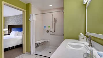 Un baño de hotel con ducha, lavamanos e inodoro.