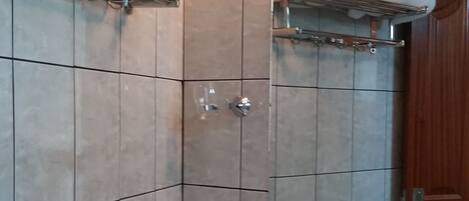 Un baño con lavamanos, toalleros y espejo.