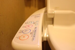 Un panneau de commande doté de nombreux boutons et indicateurs, probablement pour des toilettes ou un appareil similaire.