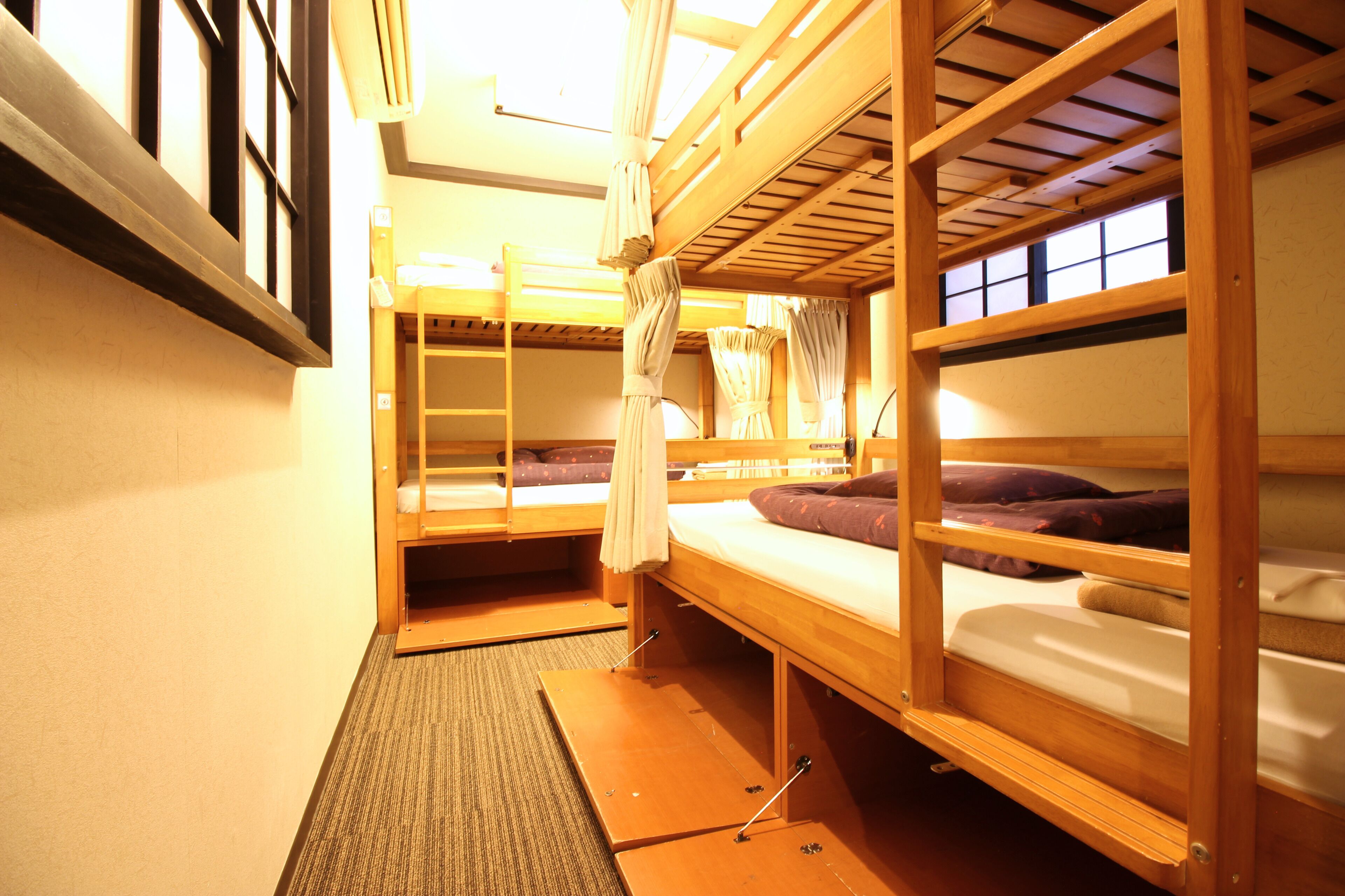 Un dormitorio con literas, un escritorio pequeño y una ventana con cortinas.