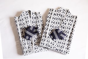 A pair of folded garments with a geometric pattern and a bow detail. - YMCA Asia Youth Center (Tokyo)