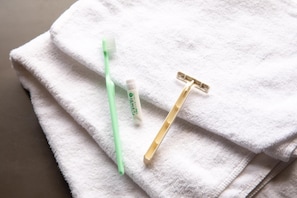A white towel with a green toothbrush and a razor. - YMCA Asia Youth Center (Tokyo)