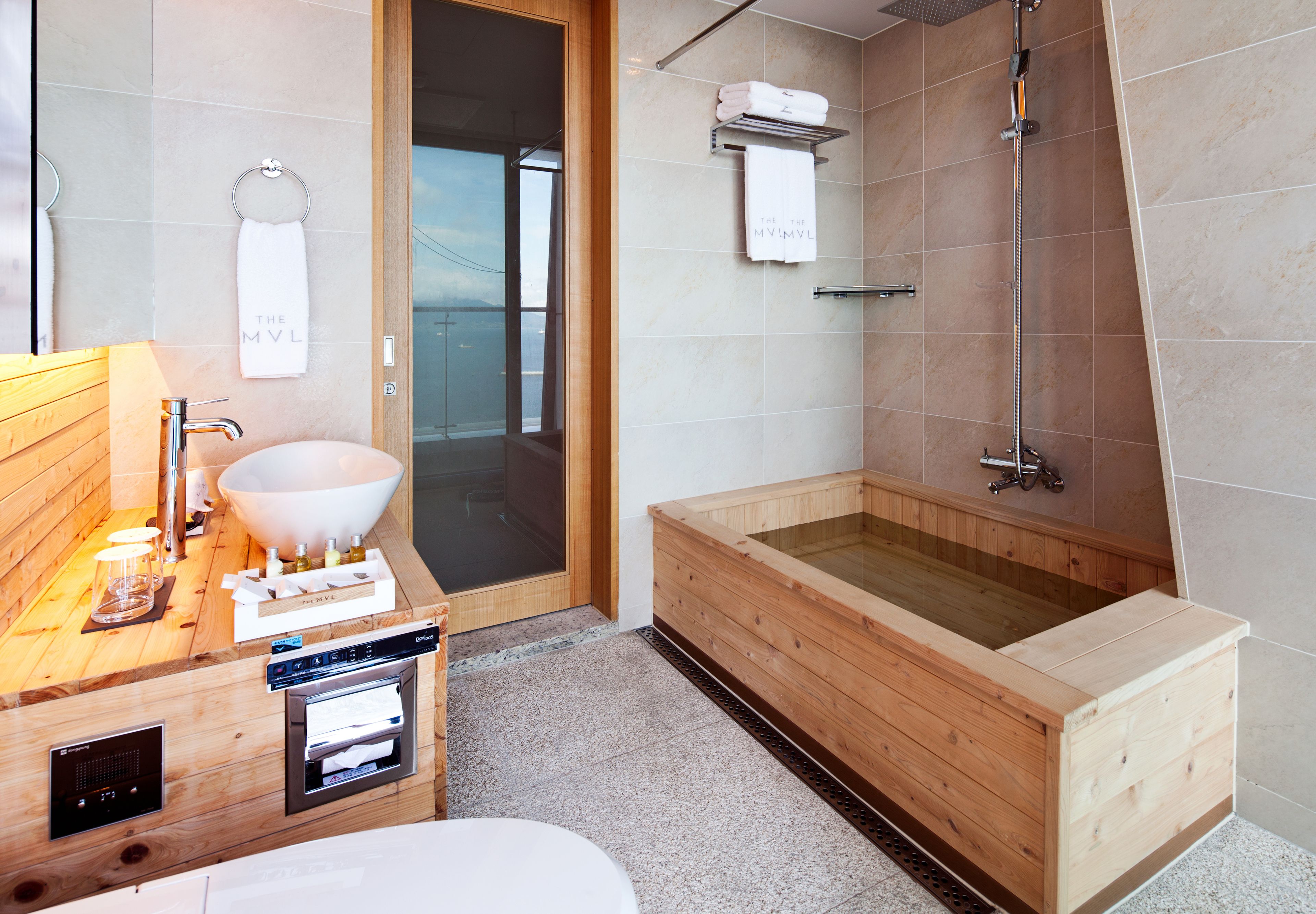 Ein modernes Badezimmer mit einem Holzwaschtisch, einem großen Waschbecken, einer Badewanne und einer Dusche.