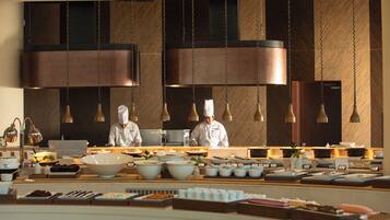 A modern kitchen with chefs preparing food, large bowls, and various kitchen utensils.