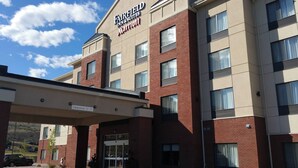 A Fairfield Inn & Suites Marriott hotel with a clear sky and a sign indicating a 12-foot clearance.