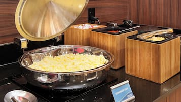 A buffet setup with scrambled eggs, a large bowl, and a sign indicating the dish.