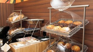 A buffet with various baked goods and pastries displayed in clear containers.