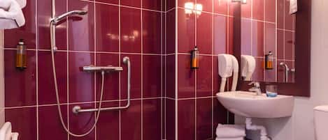 A modern bathroom with a shower, sink, and toilet.