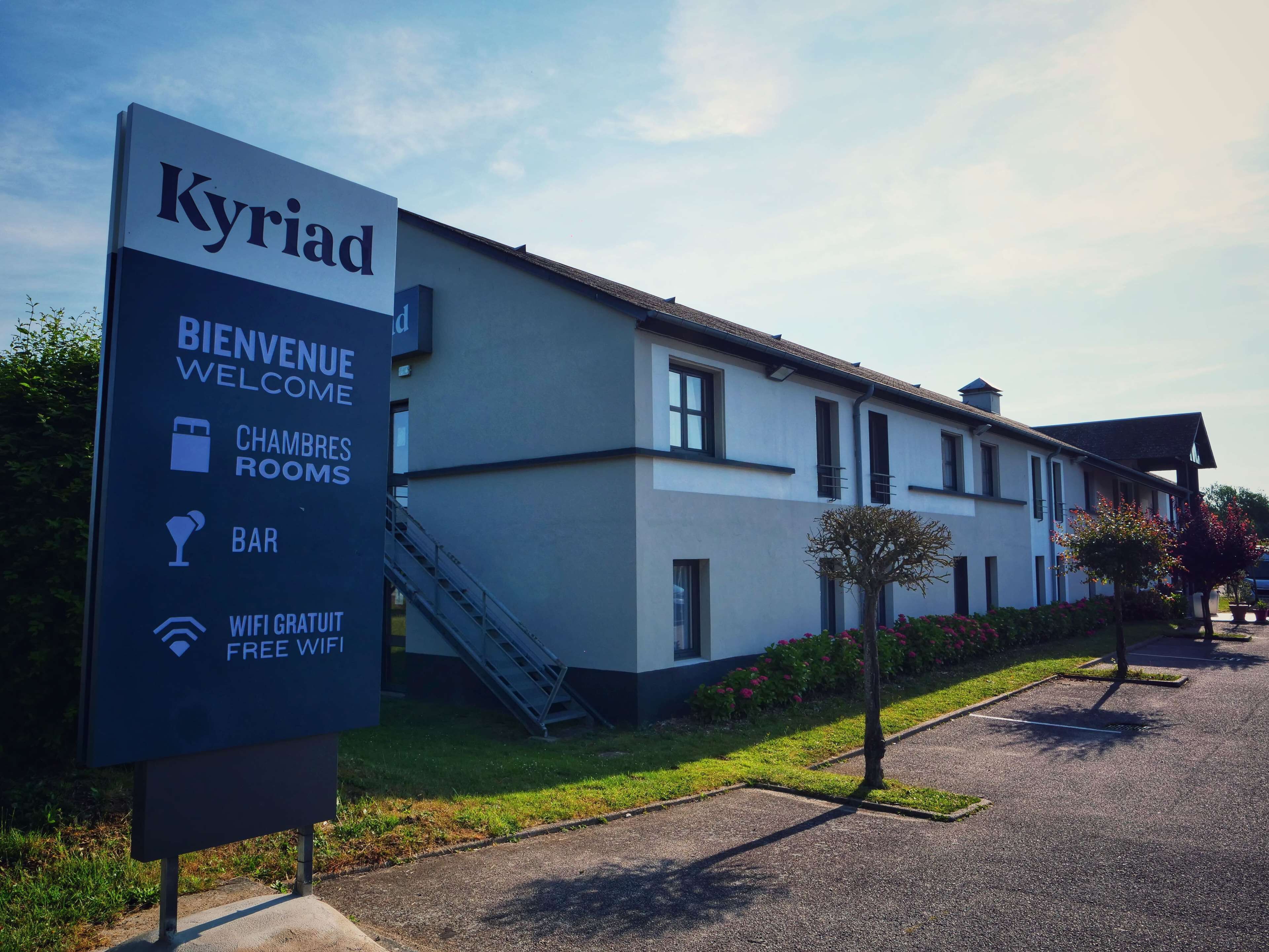 A sign for a hotel named 'Kyriad' with amenities including welcome, chambers rooms, bar, and free WiFi.
