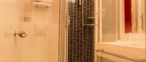 A small bathroom with a shower, toilet, and a sink.